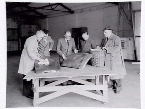 Austin Motor Co., 109 Dudley St., West Melbourne, executives shaking hands, examining car body parts and checking opened crate of body components, 1949