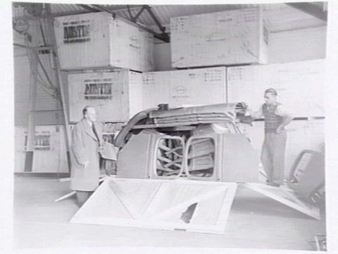 Austin Motor Co., 109 Dudley St., West Melbourne, executives shaking hands, examining car body parts and checking opened crate of body components, 1949