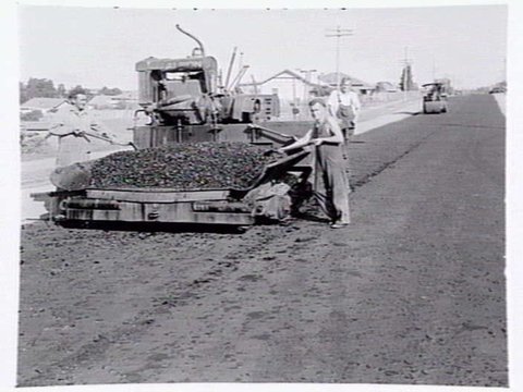 Roadmaking by Albion Quarrying P/L, showing machine laying asphalt and section of road in Heidelberg yet to be resurfaced, 1950