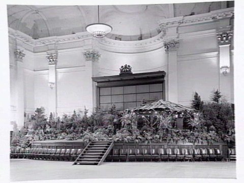 South Melbourne Town Hall, stage area decorated with plants and bark roofed hut, 1950?