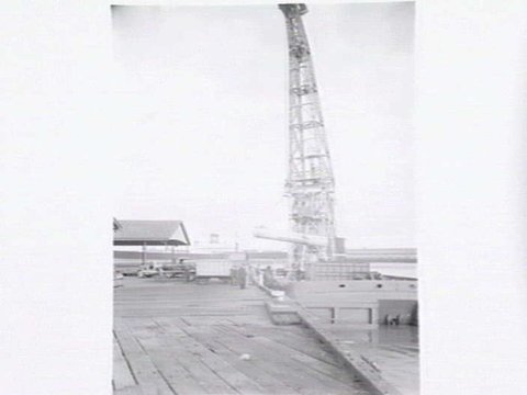 Melbourne Harbour Trust 40 ton floating crane lifting a boiler onto or from a low loader at wharf, 1949