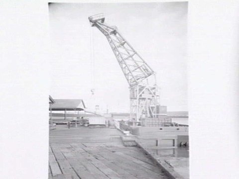 Melbourne Harbour Trust 40 ton floating crane lifting a boiler onto or from a low loader at wharf, 1949
