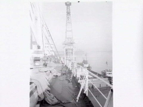 Melbourne Harbour Trust 40 ton floating crane lifting a boiler onto or from a low loader at wharf, 1949