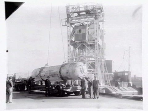 Melbourne Harbour Trust 40 ton floating crane lifting a boiler onto or from a low loader at wharf, 1949
