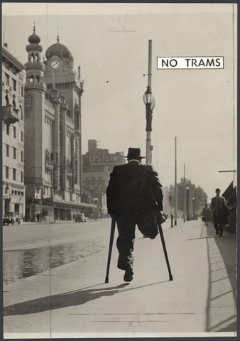 Mr. Harry Cull, liftman from the Treasury Building, walking along Flinders Street during a tram strike, 1948