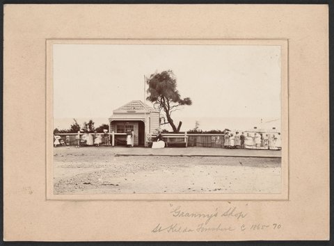 Granny's Shop on the Esplanade, St. Kilda. Royal Ladies Baths in the background, c. 1870