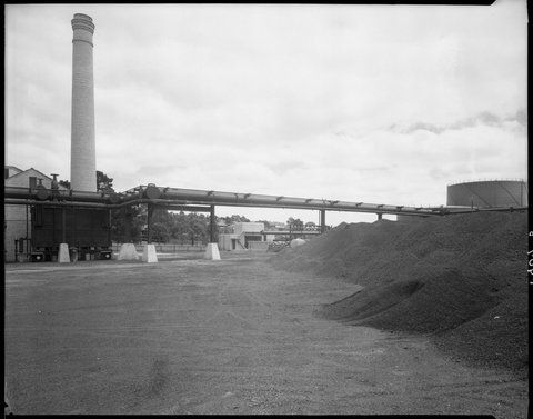 Exterior view of factory buildings and coal mounds, Colonial Gas Association, Box Hill, c. 1945
