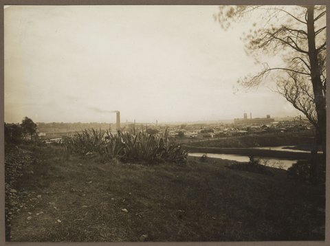 View from near Kensington Road, South Yarra, looking west, with Bryant & May at right of image; in the foreground, the Yarra River and the billabong to the east of Mary Street, Richmond. The new Church Street Bridge can be seen under construction behind the aloe, 1922