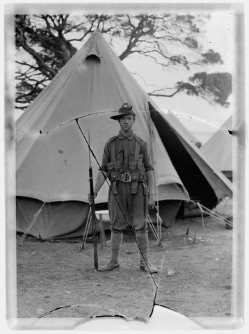 Whole-length full face soldier from 64th (City of Melbourne) Infantr, standing at ease in front of tent, c. 1915