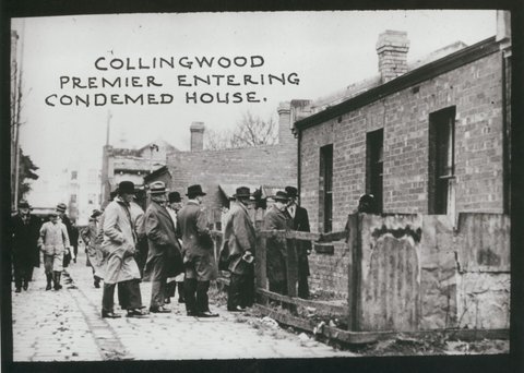Collingwood. Premier entering condemed [i.e. condemned] house, c. 1935