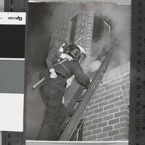 Senior fireman E. J. Goodwin rescues Miss Valerie Milne from a phosphorous fire, Malvern A.F.S. [i.e. Auxiliary Fire Service], c. 1942