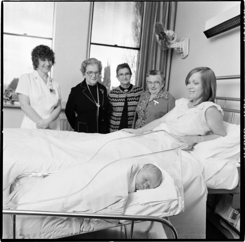 St. Georges hospital, Kew. Ladies Auxiliary and a bassinet - with new mother and baby, 1979