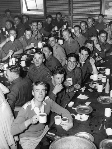Troops finishing dessert during Christmas dinner provided by members of the Royal Park Camp Women's Auxiliary, 1940–46