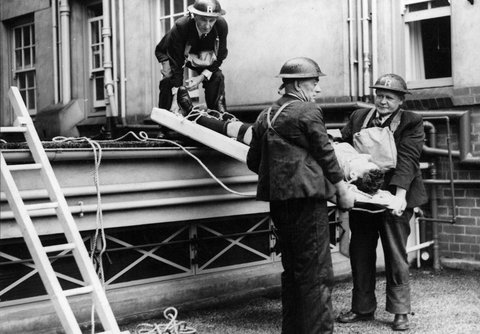 A "badly burned" victim tied to a cradle in readiness for lowering from 1st floor of Chevron Guest House, St. Kilda Rd, c. 1942