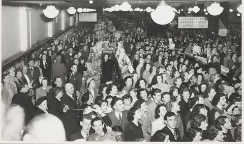 Interior crowd men and women in store for a manequin parade (models out of picture) Bourke Street Store No. 12, 1952