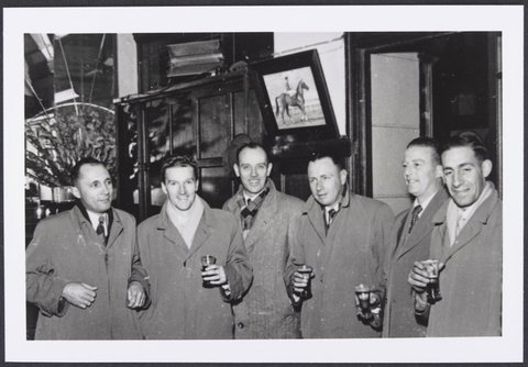 Six members of the Colesanco Table Tennis Club Melbourne Team all wearing overcoats some holding a glass of beer, 1954
