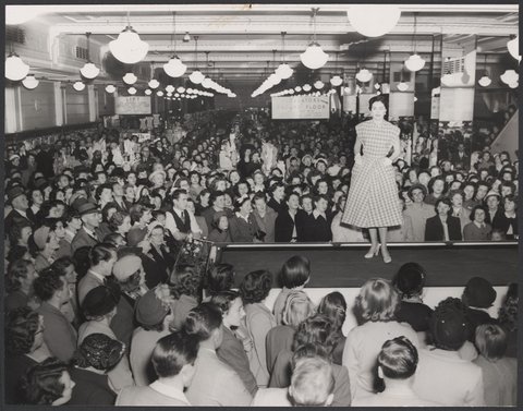 Interior of Coles Bourke Street store showing a crowd watching a mannequin parade Store No. 12, 1954