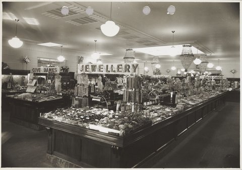 Interior of Coles store with merchandise on display including jewellery and men's ties priced from 6d. Williamstown Store No. 73, 1930–40