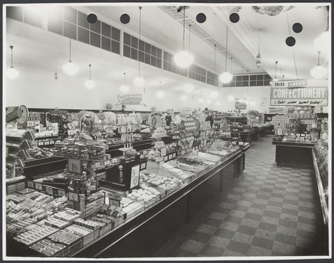 Elevated view of interior showing display counters of toiletries and advertising for confectionery in Coles Collingwood Store No. 1, 1936