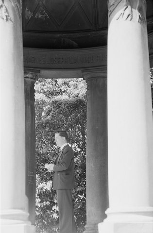 Man standing between the pillars of the Temple of the Winds in Royal Botanic Gardens, Melbourne, 1954