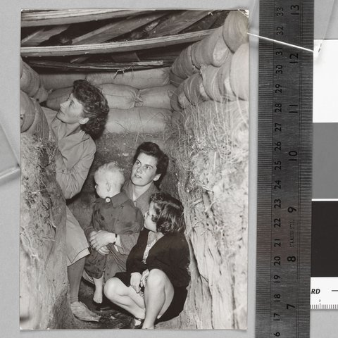 Suburban Housewives at Brighton take shelter in the backyard dug-out, c. 1942