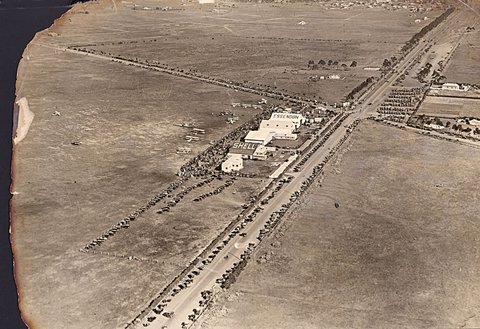 Aerial view of Essendon Airport with crowds and small aircraft, 1920–40