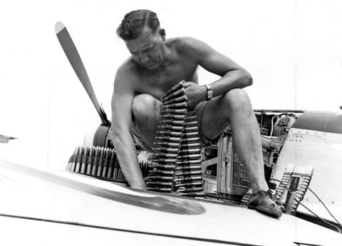 One of the ground crew, L.A.C. J. Fisher [Richmond, Vic.] loading machine-gun belts preparatory to a sortie, c. 1950