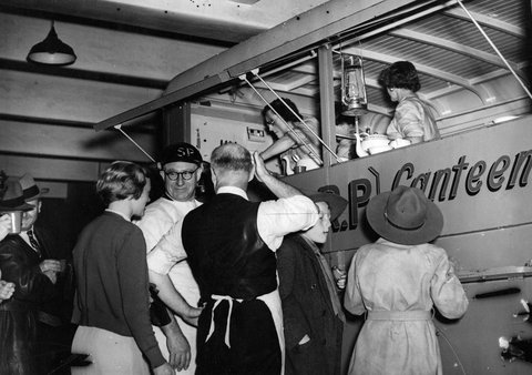 Two women serve food inside mobile Air Raid Precautions Squad canteen at Russell Street, c. 1942