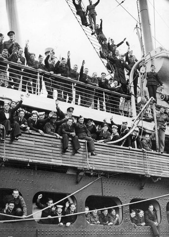 Troops of the R.A.A.F, A.I.F. and the R.A.N. "C" Contingent line the rails of the deck of the troopship as it leaves Port Melbourne wharf, c. 1940