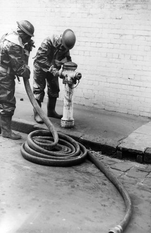 Air Raid Prevention Decontamination Squad attach hose to fire hydrant during simulated gas attack in Melbourne, c. 1939