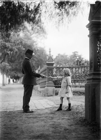 Small girl and postman outside gate of "Craigallan", Moonee Ponds, 1910–30